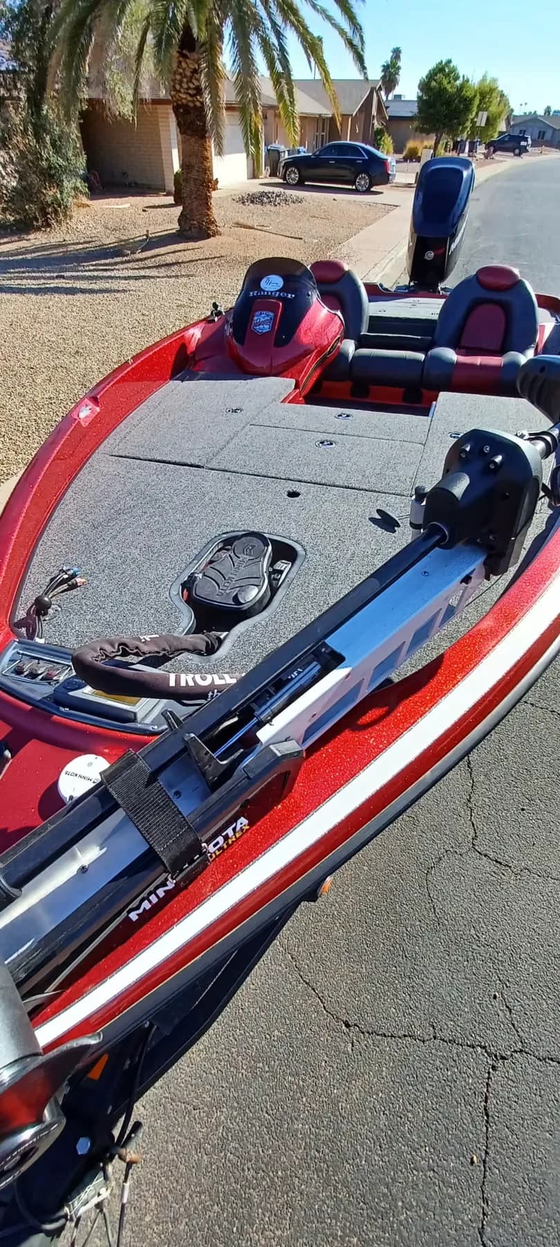 Overhead view of a red Ranger bass boat bow deck with a Minn Kota trolling motor stowed along the gunwale